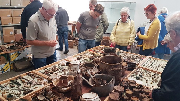 Besuchende begutachten Fundstücke